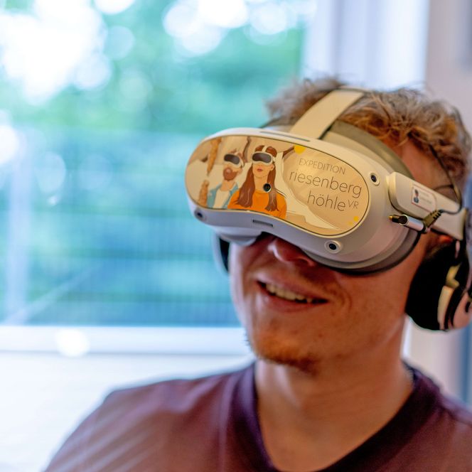 natour.NAH.zentrum Schillat-Höhle - VR-Show, Mann, der die VR-Brille trägt und die Show anschaut, Hessisch Oldendorf