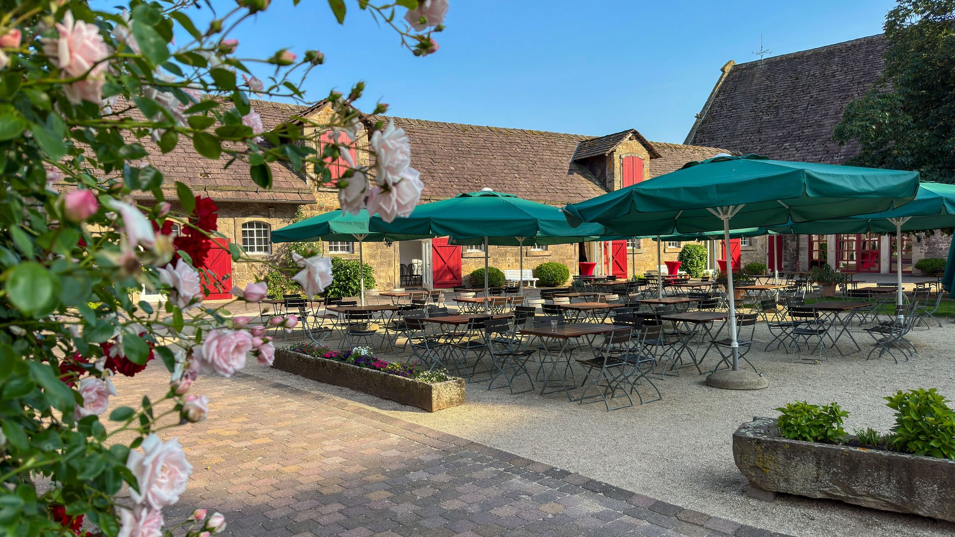 Schloss Hämelschenburg - Hof des Cafés mit Tischen und Sonnenschirmen, Emmerthal