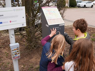 Kinder bedienen die Hörstation mit der Kurbel um Geschichten zu hören