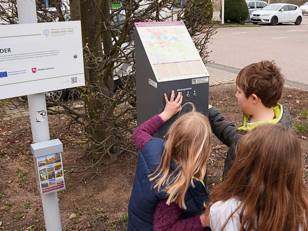 Kinder bedienen die Hörstation mit der Kurbel um Geschichten zu hören