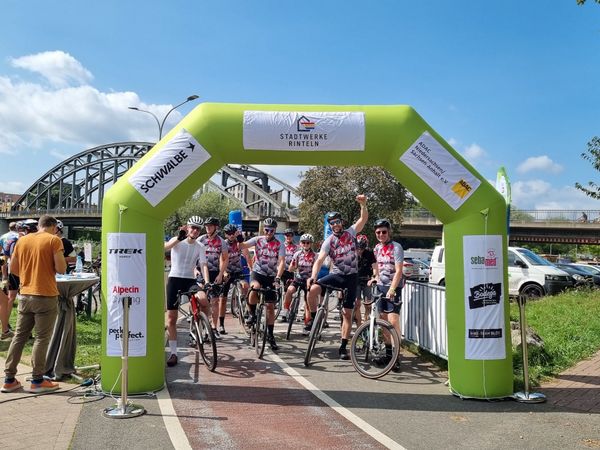 Team Radfahrer unter dem Startbogen (grün) mit Moderator bei der GROSSEN WESERRUNDE