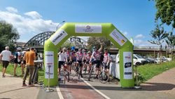 Team Radfahrer unter dem Startbogen (grün) mit Moderator bei der GROSSEN WESERRUNDE